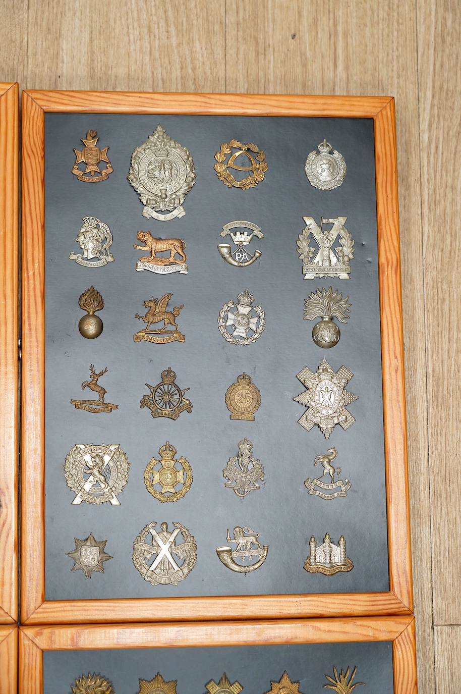 A collection of ninety-seven military cap badges mounted on four boards including; The City of London Yeomanry, Duke of Lancaster‘s Own, Bedfordshire Regiment, Leicestershire Regiment, Seventh Battalion Hampshire Regimen